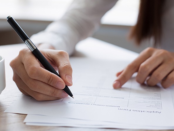 Woman writing on application form